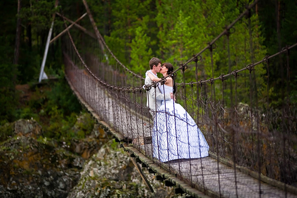 Жених и невеста целуются на мосту