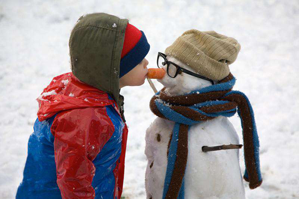 Мальчик и снеговик с морковкой