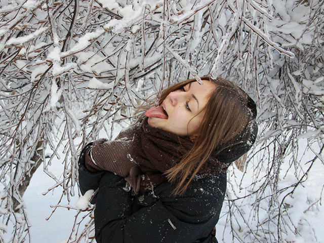 Девушка ест снег и лёд на ветках