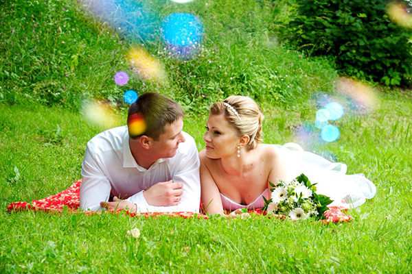 Жених и невеста лежат на траве