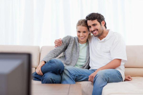 Муж и жена смотрят вдвоём фильм по телевизору