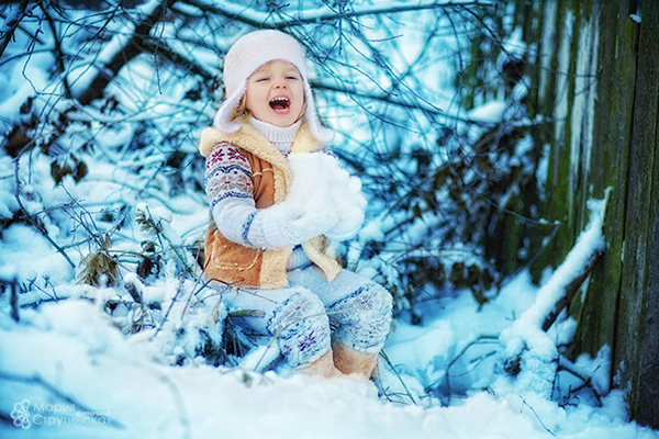 Девочка со снегом возле забора